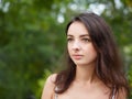 Close up portrait of young beautiful brunette woman with adorable smile enjoying sunlight in city park Royalty Free Stock Photo