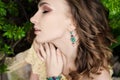 Close-up portrait of young beautiful girl with curly hair summer dress in tropical forest Royalty Free Stock Photo