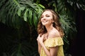 Close-up portrait of young beautiful girl with curly hair summer dress in tropical forest Royalty Free Stock Photo