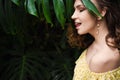 Close-up portrait of young beautiful girl with curly hair summer dress in tropical forest Royalty Free Stock Photo