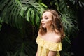 Close-up portrait of young beautiful girl with curly hair summer dress in tropical forest Royalty Free Stock Photo