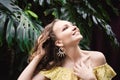 Close-up portrait of young beautiful girl with curly hair summer dress in tropical forest Royalty Free Stock Photo