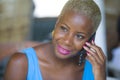 Close up portrait of young beautiful and happy black afro american business woman in trendy and stylish hair talking happy on mobi Royalty Free Stock Photo