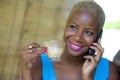 Close up portrait of young beautiful and happy black afro American business woman in trendy stylish hair talking on mobile phone d Royalty Free Stock Photo