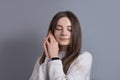 Close up portrait of young beautiful happy smiling girl woman touching her face  cheeks pleasure. Studio shot on grey background Royalty Free Stock Photo