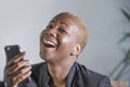 Close up portrait of young beautiful and happy trendy black afro american woman holding and using mobile phone isolated on grey ba Royalty Free Stock Photo