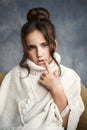 Close up portrait of young beautiful pensive girl in white sweater looking at camera. Royalty Free Stock Photo