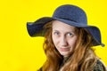 Close-up Portrait of a young beautiful red-haired girl with long loose hair, looking tenderly at the camera. On a yellow Royalty Free Stock Photo