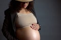 Close-up portrait of young beautiful pregnant woman gently caressing her belly, enjoying her happy carefree pregnancy Royalty Free Stock Photo