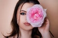 Close-up portrait of young beautiful sexy woman with pink rose near face. Royalty Free Stock Photo