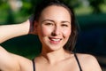 Close up portrait of a young beautiful smiling happy brunette girl in outdoor Park on a Sunny summer day correcting hand loose Royalty Free Stock Photo