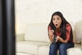 Close up portrait young beautiful Spanish woman home watching television on couch happy excited Royalty Free Stock Photo