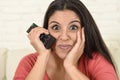 Close up portrait young beautiful Spanish woman home watching television on couch happy excited