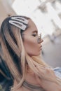 Close up portrait of a young beautiful woman with natural hairstyle. Her tresses are adorned with pearl hair clips