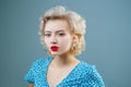 Close up portrait of young beautiful woman with pinup style, hoop earrings, posing on gray Isolated background. Copy