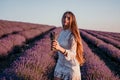 Woman lavender field. Happy carefree woman in a white dress walking in a lavender field and smelling a lavender bouquet Royalty Free Stock Photo