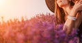 Woman lavender field. Happy carefree woman in black dress and hat with large brim smelling a blooming lavender on sunset Royalty Free Stock Photo
