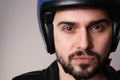 Close up of biker in motorcycle black helmet and leather jacket on white wall. Royalty Free Stock Photo