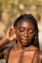 Close-up portrait of a young black female removing her hair from her face whit her eyes closed