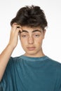 Close up portrait of a young boy scratching his head with his right hand desperate from life`s problems Royalty Free Stock Photo