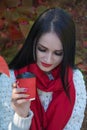 Close-up portrait of young brunette woman holding a red paper cup in her hand