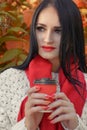 Close-up portrait of young brunette woman in white bolero and red scarf,