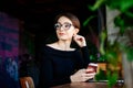 Portrait of young business woman in coffee shop holding smart phone in her hands Royalty Free Stock Photo