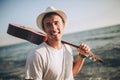 Portrait of a young casual man with guitar on his shoulder on the beach Royalty Free Stock Photo