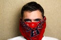 Close-up portrait of young caucasian brown-haired man in red bandana on face at home looking at camera. Lifestyle. Handsome guy. Royalty Free Stock Photo