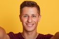 Close up portrait of young charismatic cool magnetic boy looking directly at camera, smiling sincerely, having pleasant facial