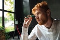 Close-up portrait of young concentrated readhead bearded man, ho Royalty Free Stock Photo