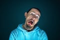 Close up portrait of young crazy scared and shocked man isolated on dark background Royalty Free Stock Photo