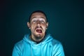 Close up portrait of young crazy scared and shocked man isolated on dark background Royalty Free Stock Photo