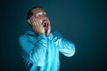 Close up portrait of young crazy scared and shocked man isolated on dark background Royalty Free Stock Photo