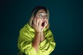 Close up portrait of young crazy scared and shocked woman  on dark background Royalty Free Stock Photo