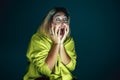 Close up portrait of young crazy scared and shocked woman  on dark background Royalty Free Stock Photo