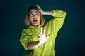 Close up portrait of young crazy scared and shocked woman  on dark background Royalty Free Stock Photo