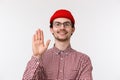 Close-up portrait of young cute caucasian guy saying hi to new team member, raising hand in hello greeting gesture Royalty Free Stock Photo