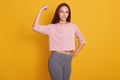 Close up portrait of young cute sporty smiling brunette woman, showing her arms and biceps on camera, demonstrating her power. Royalty Free Stock Photo