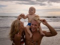 Close up portrait of young family of father, mother and son spending time on the beach. Father carrying child on neck. Happy mum Royalty Free Stock Photo