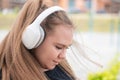 Close-up portrait of a young fat woman with headphones. Beautiful chubby girl listening to music outdoors Royalty Free Stock Photo