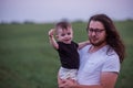 Close up portrait of young father with long hair, beard, glasses holds little son. Fathers day Royalty Free Stock Photo