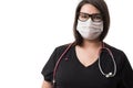 Close up portrait of a young female doctor in a black uniform and a mask wearing a stethoscope, isolated on white background Royalty Free Stock Photo