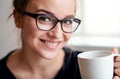 A close-up portrait of young female student, holding cup of coffee. Royalty Free Stock Photo