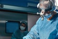 Close up portrait of young female surgeon doctor wearing protective mask and hat during the operation. Healthcare Royalty Free Stock Photo