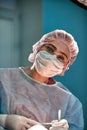 Close up portrait of young female surgeon doctor wearing protective mask and hat during the operation. Healthcare Royalty Free Stock Photo