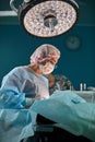 Close up portrait of young female surgeon doctor wearing protective mask and hat during the operation. Healthcare Royalty Free Stock Photo