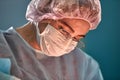 Close up portrait of young female surgeon doctor wearing protective mask and hat during the operation. Healthcare Royalty Free Stock Photo