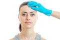Close-up portrait of a young girl at a cosmetologist in a blue glove