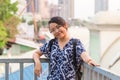 Close up portrait young glasses Asian woman looking at camera with smile, learning railing bridge while traveling in Bangkok Royalty Free Stock Photo